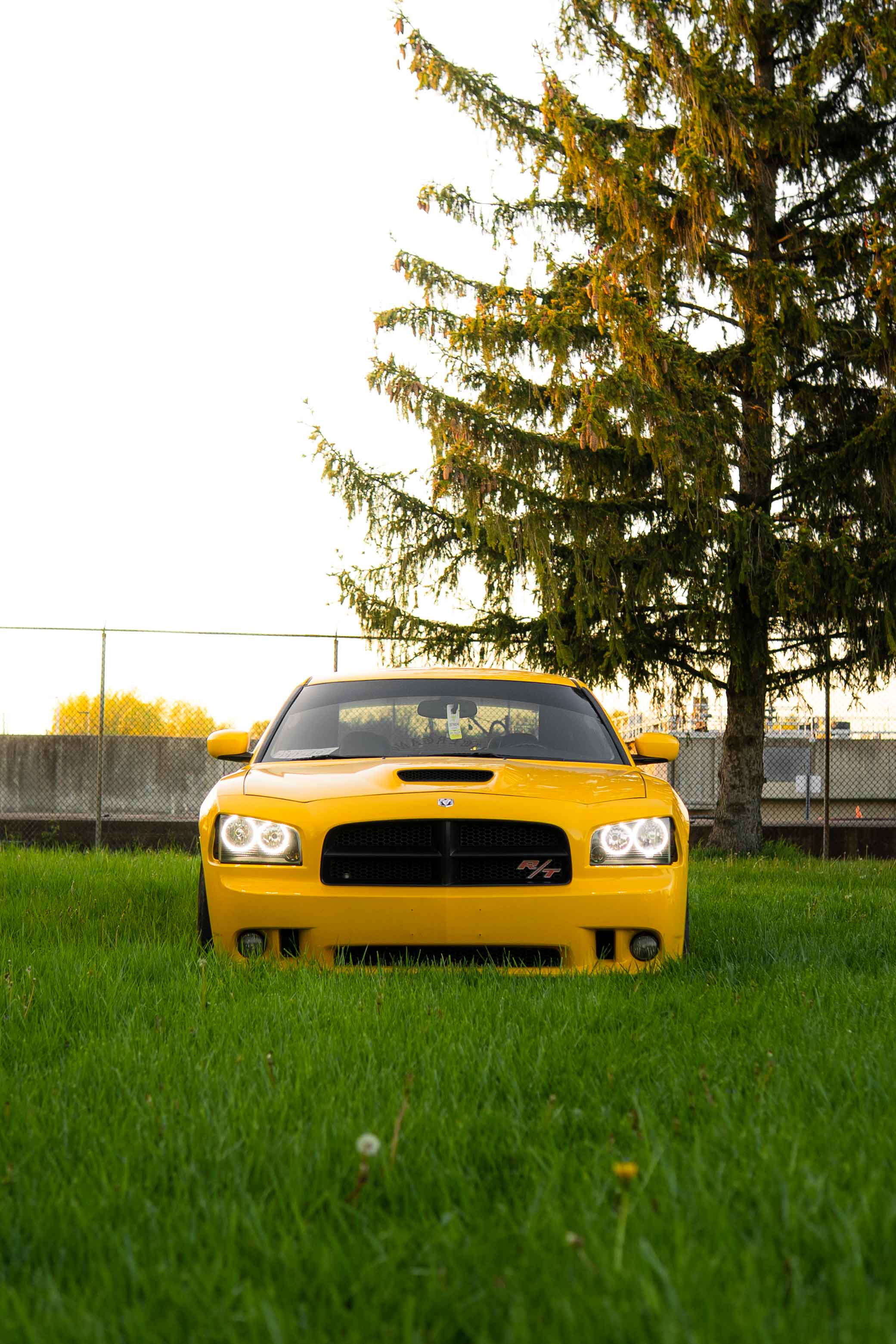 Front angle Dodge Daytona with headlights on at sunset