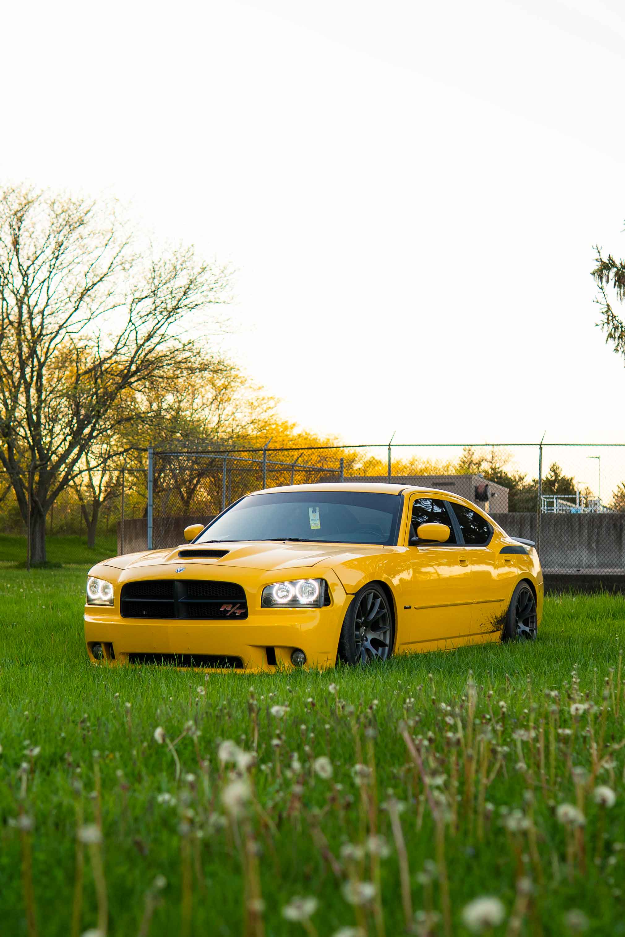 Head-on shot of Dodge Daytona with lights on, parked in grass
